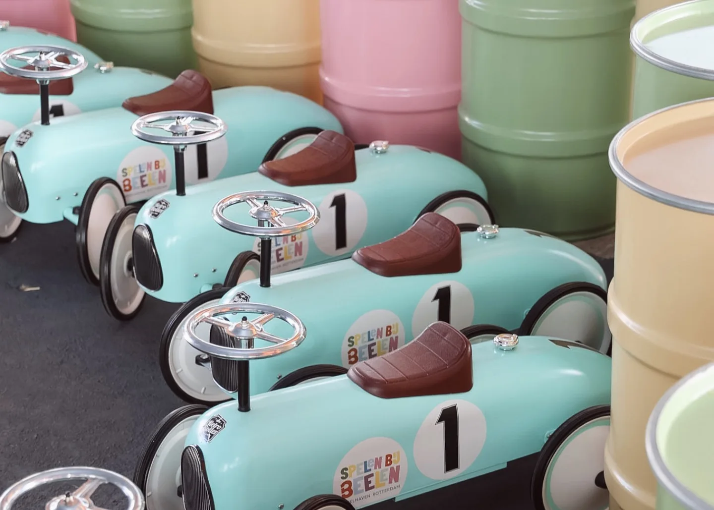 A row of mint-green Spelen bij Beelen pedal cars